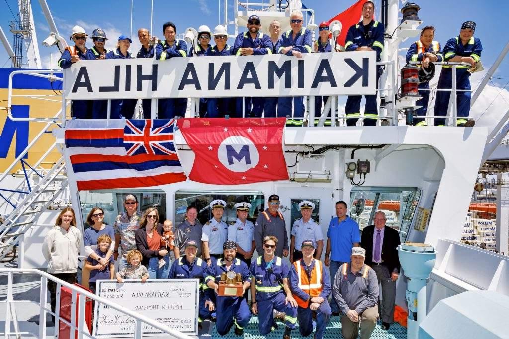 凯马纳希拉号船员拿着船名板聚集在舰桥的顶部和前面, 澳博体育app和夏威夷州旗, 展示检查.